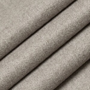 May include: Close-up of a gray herringbone fabric with a subtle white pattern. The fabric is folded in a way that shows the texture and weave.