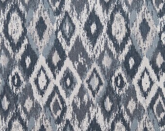 May include: A blue and white fabric with a geometric pattern. The pattern is made up of diamonds and swirls.