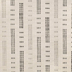 Può includere: Un tessuto beige con un motivo ripetitivo di linee e punti neri e grigi. Il motivo è un design geometrico semplice.