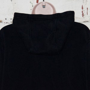 May include: Black hooded sweatshirt with a drawstring hood. The sweatshirt is made of a soft, comfortable fabric.