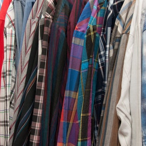 May include: A collection of plaid shirts in various colours and patterns, including red, blue, green, and black.