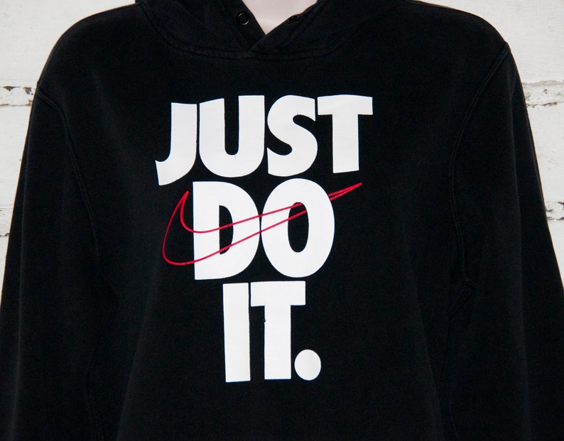 May include: Black hooded sweatshirt with a white "Just Do It" logo and a red Nike swoosh.