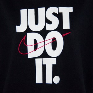 May include: Black sweatshirt with white text that reads "Just Do It." The Nike swoosh logo is in red.