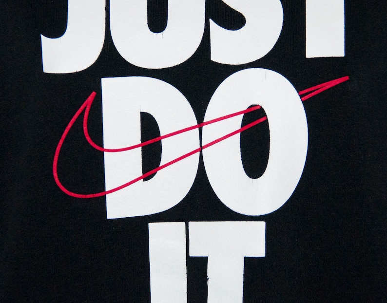 May include: Black t-shirt with white text that reads "Just Do It" and a red Nike swoosh.