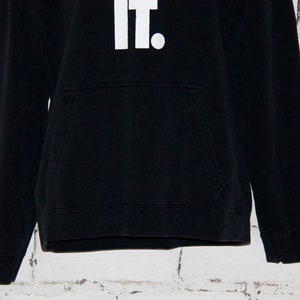 May include: Black hooded sweatshirt with a white "Just Do It." graphic on the front.