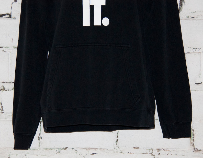 May include: Black hooded sweatshirt with a white "Just Do It." graphic on the front.