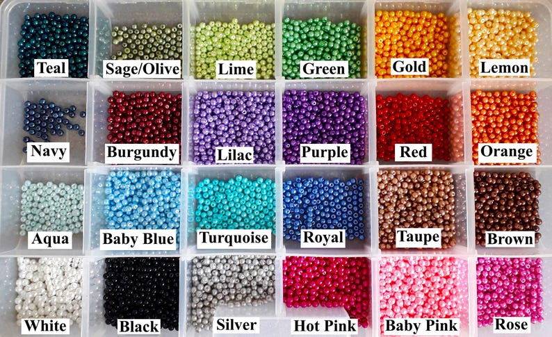 May include: A clear plastic storage container with twenty-four compartments filled with small, round, colored beads. Each section contains a specific color labeled with text including Teal, Sage/Olive, Lime, Green, Gold, Lemon, Navy, Burgundy, Lilac, Purple, Red, Orange, Aqua, Baby Blue, Turquoise, Royal, Taupe, Brown, White, Black, Silver, Hot Pink, Baby Pink, and Rose.