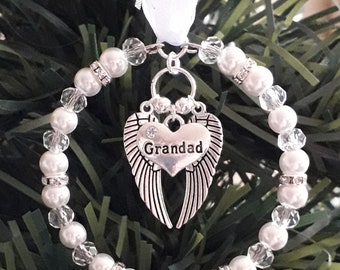May include: White beaded Christmas ornament with a silver heart charm that says "Grandad" and angel wings.