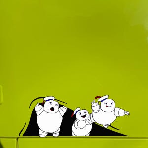 May include: Three white marshmallow men with black eyes and mouths, wearing sailor hats, are peeking out from behind a black shape. The marshmallow men are on a green background.