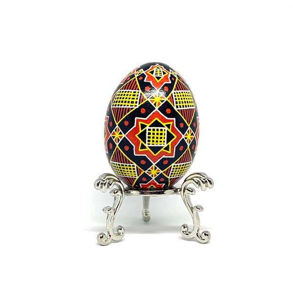 Handmade original artwork star and netting design pysanka on a real chicken eggshell white yellow red black Ukrainian Easter egg keepsake