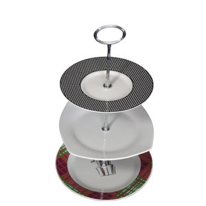 Op de afbeelding: Een drielaags taartstandaard met een zilveren metalen standaard en drie witte keramische borden. Het bovenste bord heeft een zwart-wit geruit patroon, het middelste bord is effen wit en het onderste bord heeft een rood, groen en wit geruit patroon.