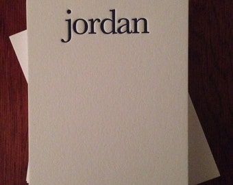 May include: A white card with the name "jordan" printed in black letters at the top. A small brown giraffe silhouette is printed at the bottom of the card.