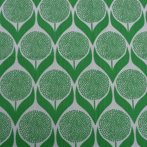May include: Green and white fabric with a repeating pattern of stylized flowers. Each flower has a circular center with a white dot pattern and green leaves.