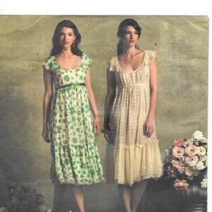 May include: Vogue pattern featuring two women modeling dresses. One dress is white with green floral print, the other is a light yellow with a dotted pattern. The pattern is designed by Anna Sui.