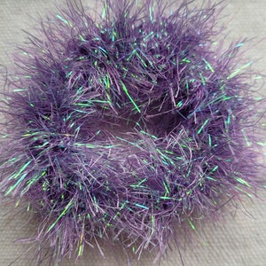 May include: A purple and iridescent fuzzy hair scrunchie.