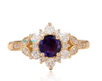 May include: A gold ring featuring a purple gemstone surrounded by smaller white gemstones.