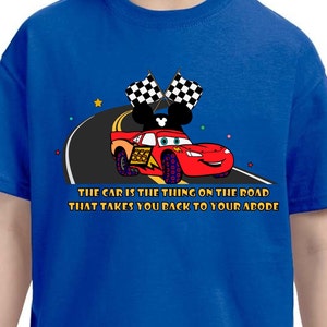May include: A blue t-shirt with a red race car and Mickey Mouse ears. The car has the number 555 on the side. The text on the shirt reads "THE CAR IS THE THING ON THE ROAD THAT TAKES YOU BACK TO YOUR ABODE".