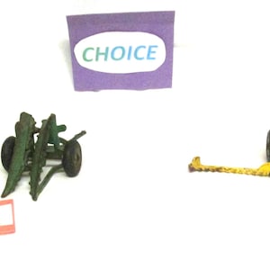 May include: A collection of vintage toy cannons in various colors, including green, brown, and yellow. The toys are arranged on a white surface, with a purple sign that says "CHOICE". Each cannon has a unique design and is labeled with a letter.