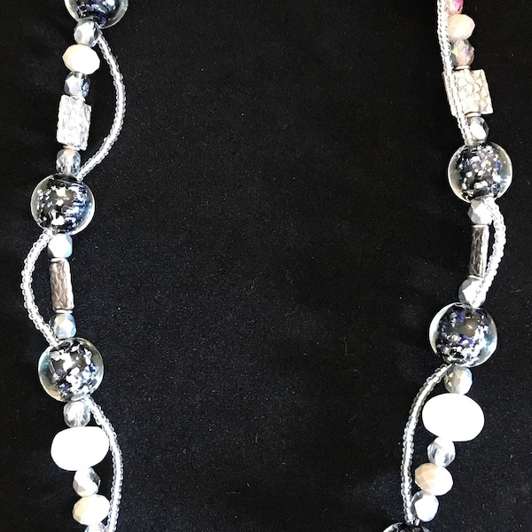 Collier exquis et boucles d’oreilles assorties avec des perles noires, claires, argentées, de pierre de lune et tchèques, avec un grand basculement en argent en forme de nénuphar.