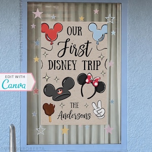 May include: A framed sign with the text "OUR First DISNEY TRIP" and "The Andersons". The sign features Mickey Mouse-themed illustrations, including balloons, ears, and a peace sign. The sign is framed in a light blue window.