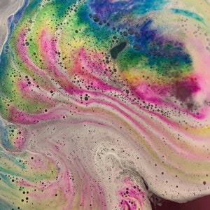 Rusted Acre Soap Company's rainbow cloud bath bomb color swirling in bath water.