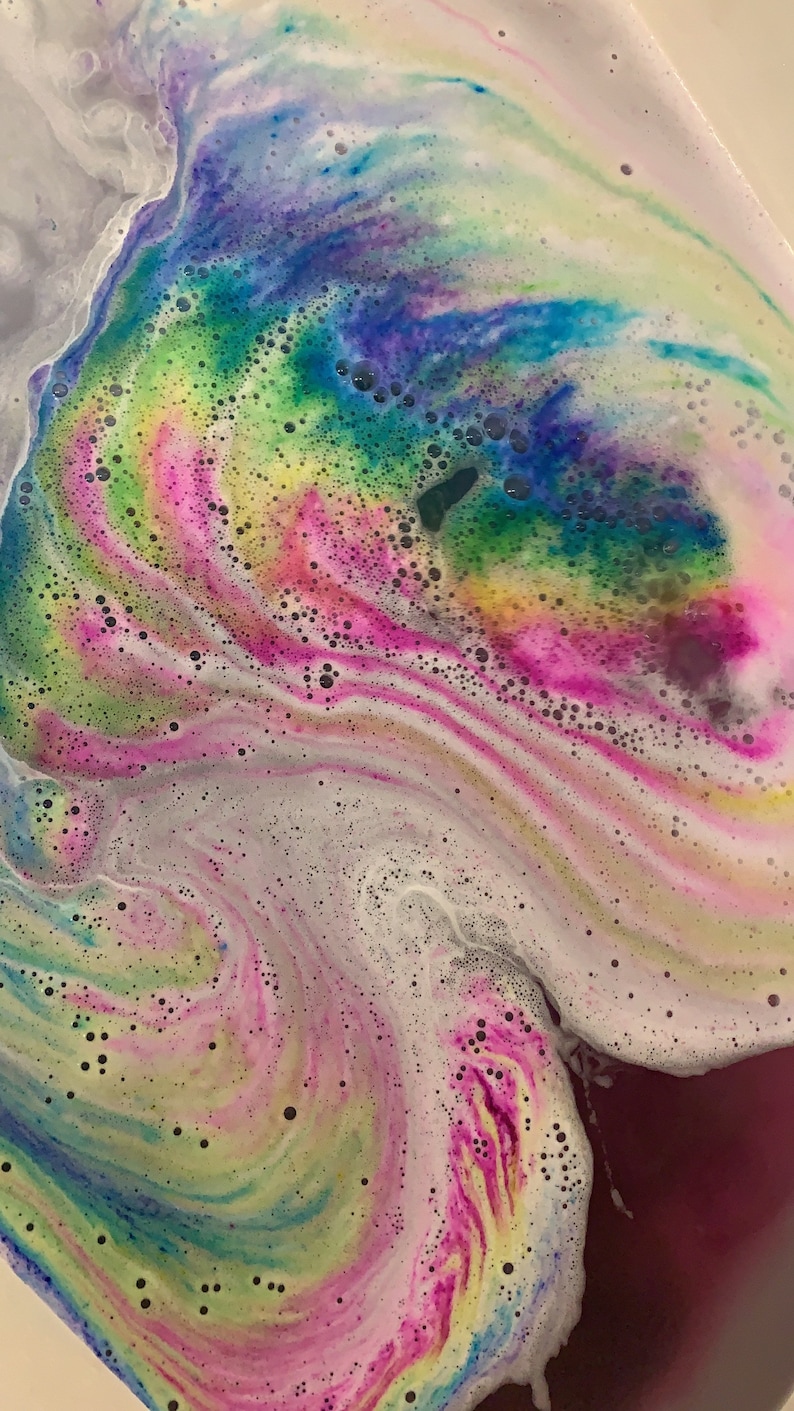 Rusted Acre Soap Company's rainbow cloud bath bomb color swirling in bath water.