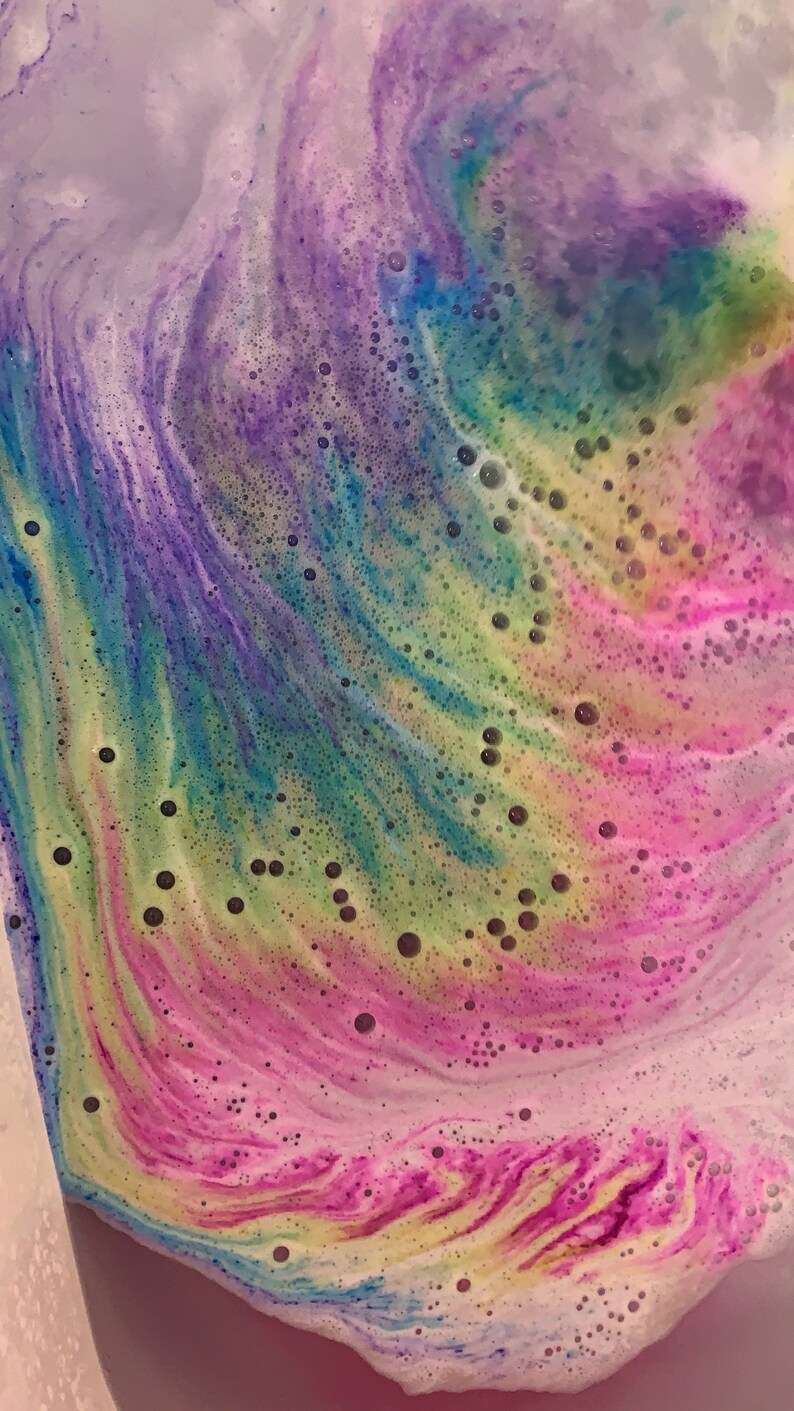 Rainbow cloud bath bomb color swirling in bath water.
