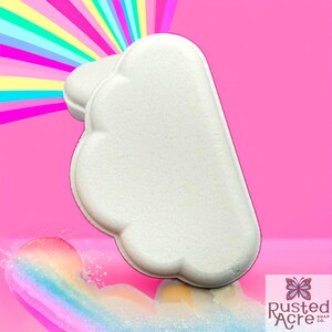 Two white rainbow cloud bath bombs handmade by Rusted Acre Soap Company with a fun background.