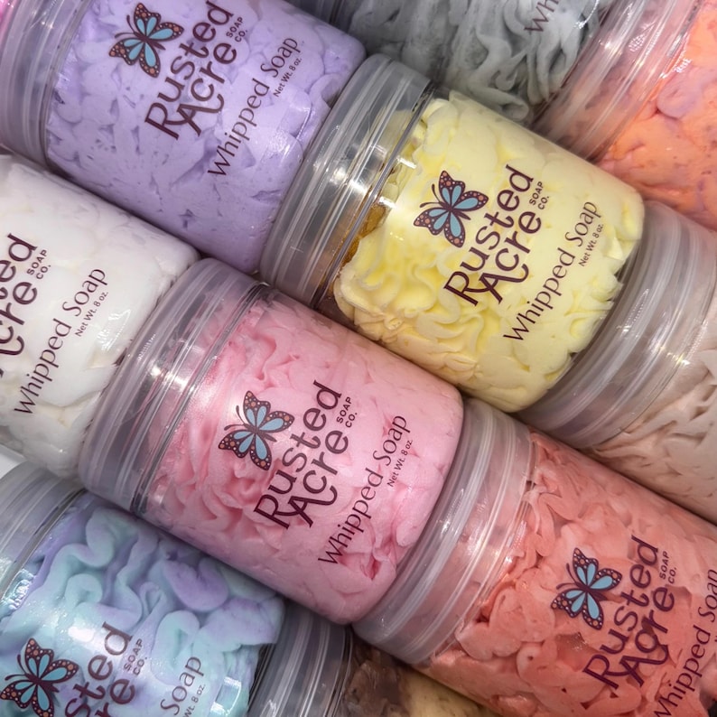 Multiple jars of Rusted Acre Soap Company's whipped soap in different scents and colors.