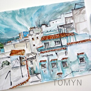 May include: Watercolor painting of a cityscape with blue and brown buildings. The buildings are clustered together and have a variety of shapes and sizes. The sky is a light blue color and there are clouds in the distance. The painting is signed "TOMYN" in the bottom right corner.