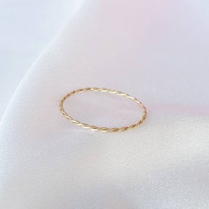 Op de afbeelding: Een eenvoudige gouden ring met een gedraaide band.