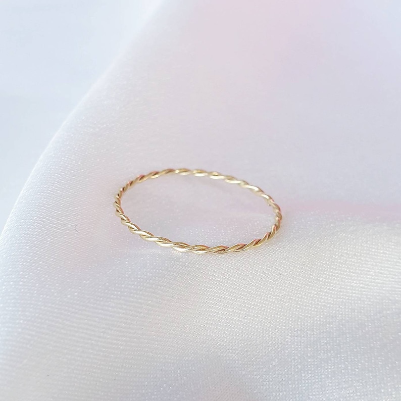 Op de afbeelding: Een eenvoudige gouden ring met een gedraaide band.