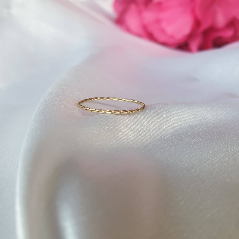 Op de afbeelding: Een eenvoudige gouden ring met een gedraaide band.