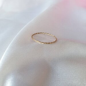Op de afbeelding: Een dunne gouden ring met een gedraaid ontwerp.
