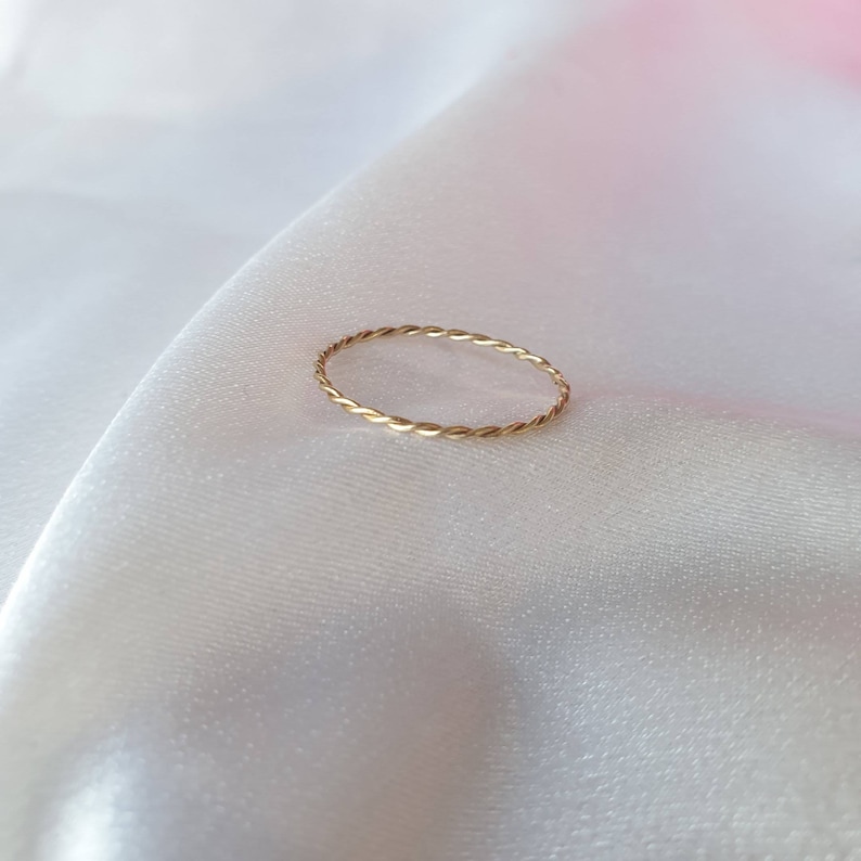Op de afbeelding: Een dunne gouden ring met een gedraaid ontwerp.