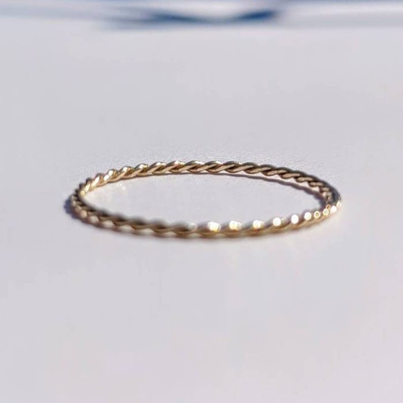 Op de afbeelding: Een dunne gouden ring met een gedraaid ontwerp.