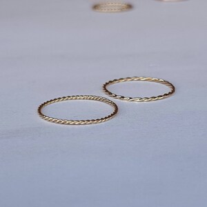 Op de afbeelding: Twee gouden, gedraaide draadringen. De ringen zijn simpel en delicaat.