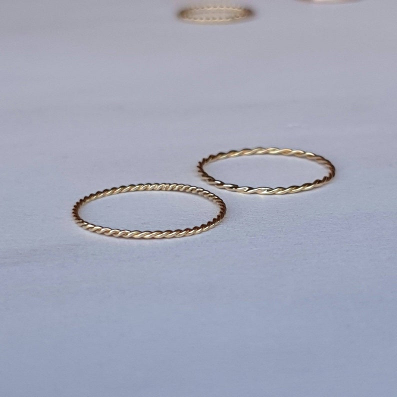 Op de afbeelding: Twee gouden, gedraaide draadringen. De ringen zijn simpel en delicaat.