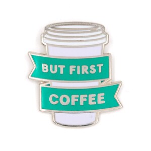 May include: A silver enamel pin with a green ribbon that says "But First, Coffee". The pin features a white coffee cup with a silver lid.