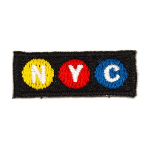 May include: A black fabric patch with three embroidered circles, each containing a white letter. The circles are yellow, red, and blue, spelling out "NYC".