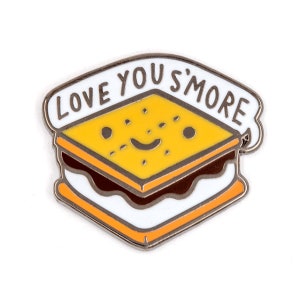 May include: A silver enamel pin with a smiling s'more graphic and the text "Love You S'more".