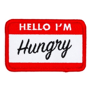 May include: Red and white name tag with the text "Hello I'm Hungry" in black embroidery.