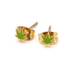May include: A pair of gold-colored stud earrings with a green marijuana leaf design.