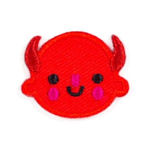 May include: Red felt embroidered patch of a cartoon devil with a smiling face, black eyes, and pink cheeks. The devil has small horns.