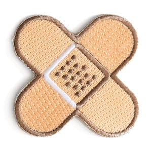 May include: A brown fabric patch shaped like a bandage with a white center and brown stitching.