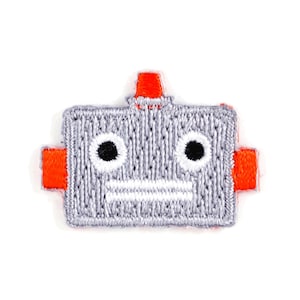 May include: A gray embroidered robot patch with orange accents. The robot has two black eyes and a white mouth.