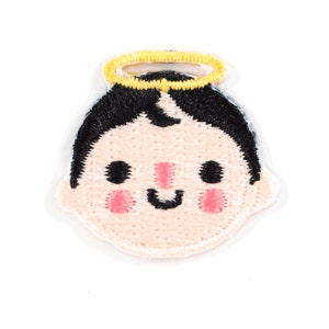 May include: Embroidered iron-on patch of a smiling cartoon angel with a halo. The angel has black hair, pink cheeks, and a pink nose.