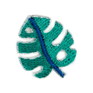 May include: A teal green embroidered monstera leaf patch with a blue outline.