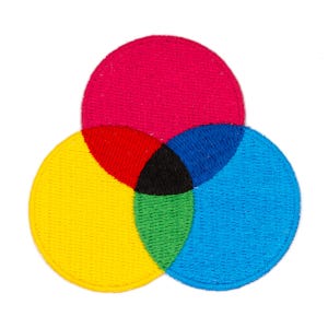 May include: A colorful embroidered patch depicting the CMYK color model. The patch features four overlapping circles in yellow, magenta, cyan, and black.