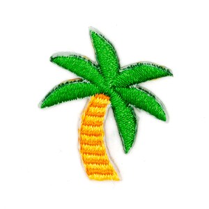 May include: A green embroidered palm tree with a yellow striped trunk. The palm tree is isolated on a white background.
